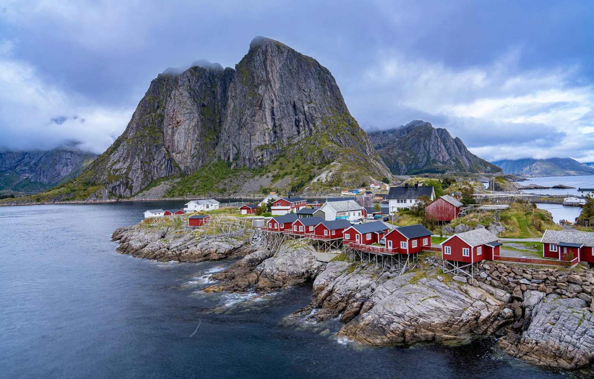 Red fishing cabins in Hamnøy under steep mountains